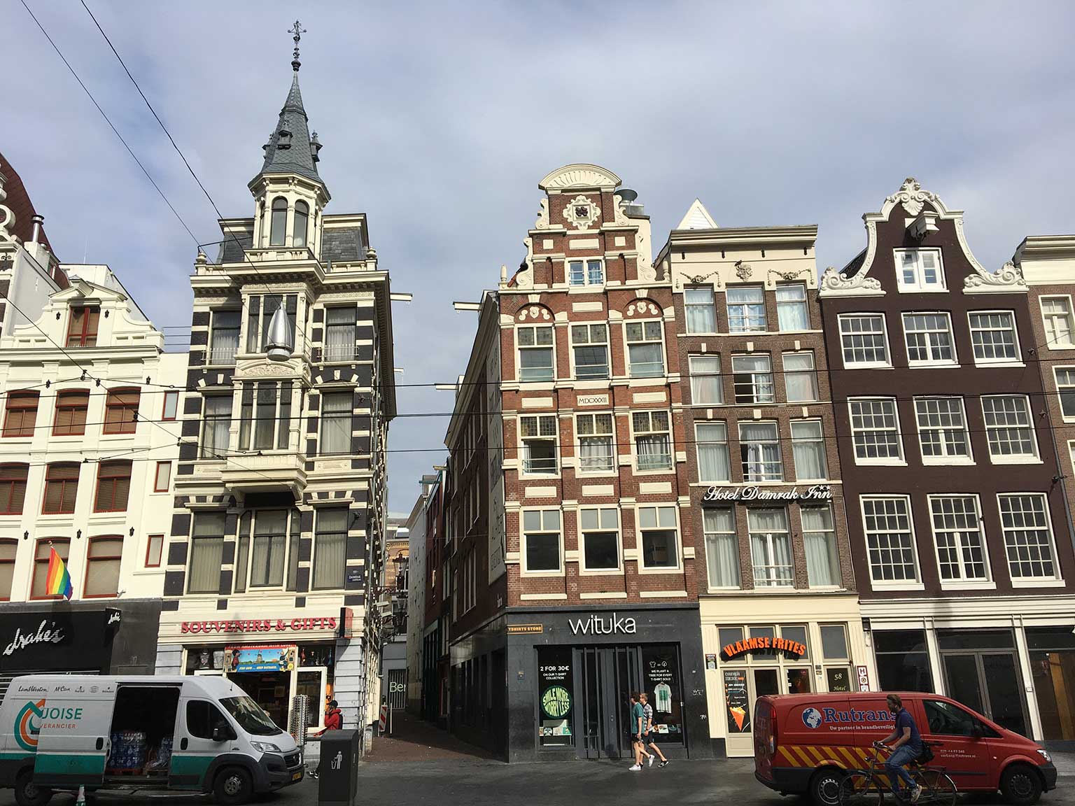 Damrak, Amsterdam, tussen de nummers 61 en 57. Tussen nummer 59 en 60 de Onze Lieve Vrouwesteeg