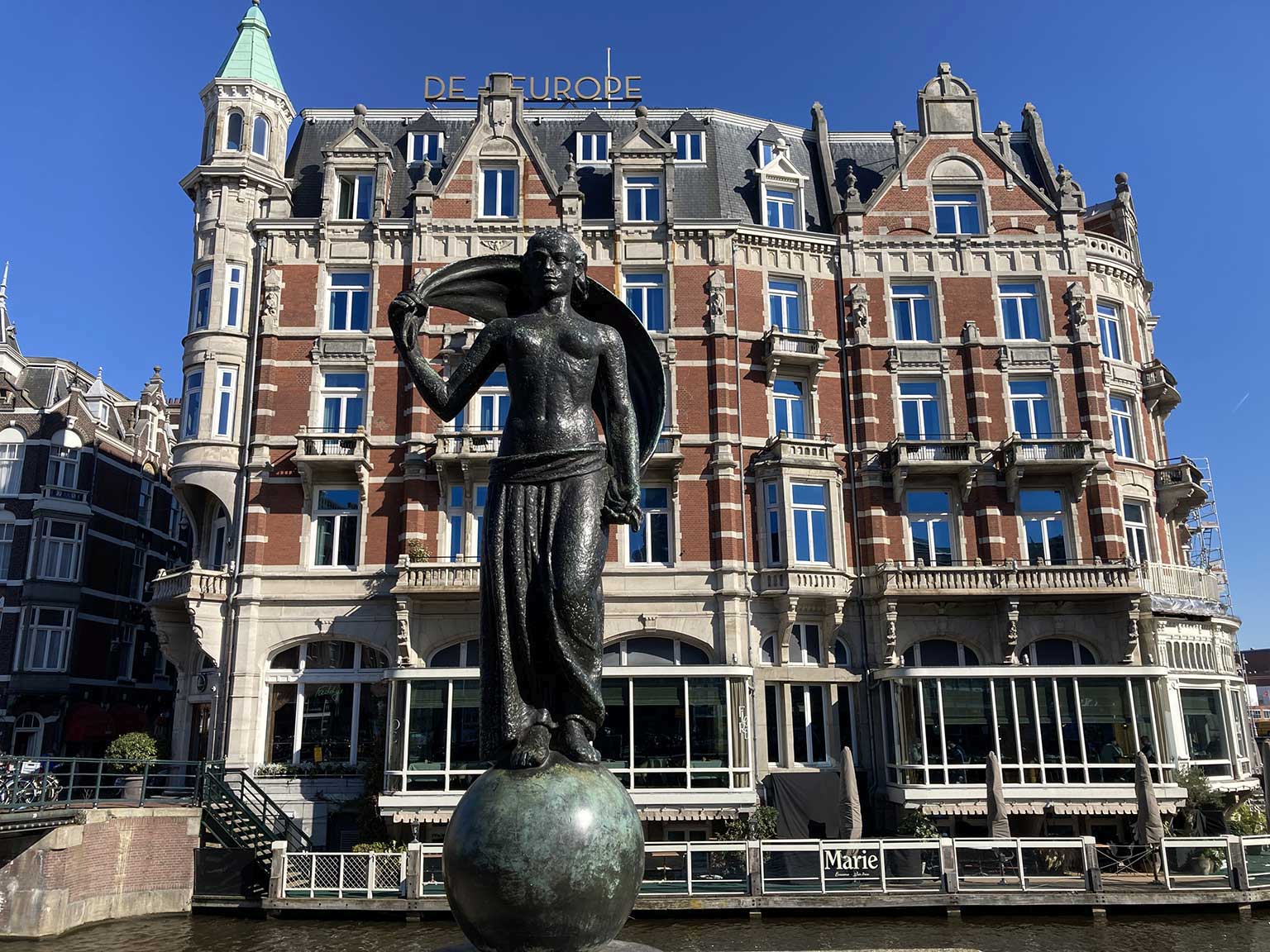De L'Europe, Amsterdam, gezien vanaf het Muntplein, met ervoor beeld Fortuna door Hildo Krop