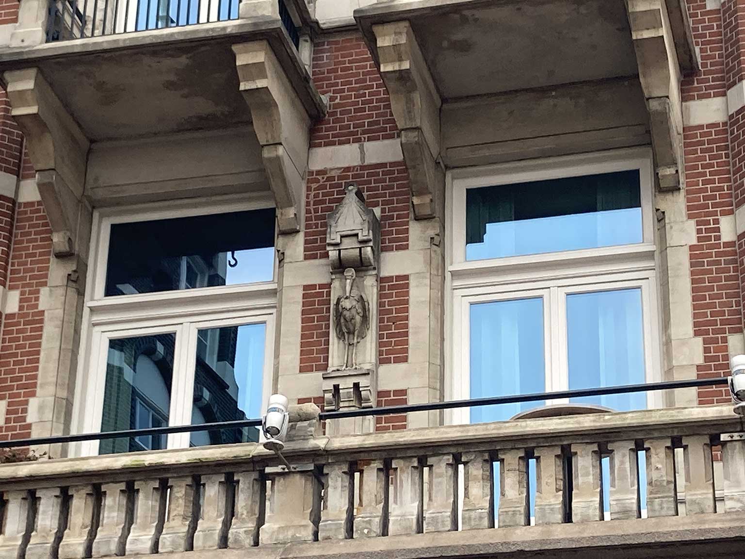 Ooievaar boven het balkon van de eerste verdieping van De L'Europe, Nieuwe Doelenstraat 2-14, Amsterdam
