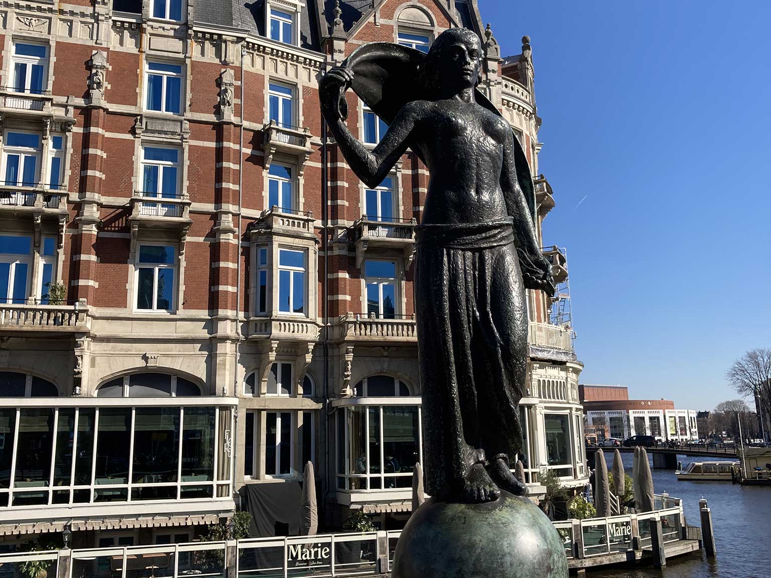 Statue Fortuna by Hildo Krop on Muntplein, Amsterdam, behind it De L'Europe