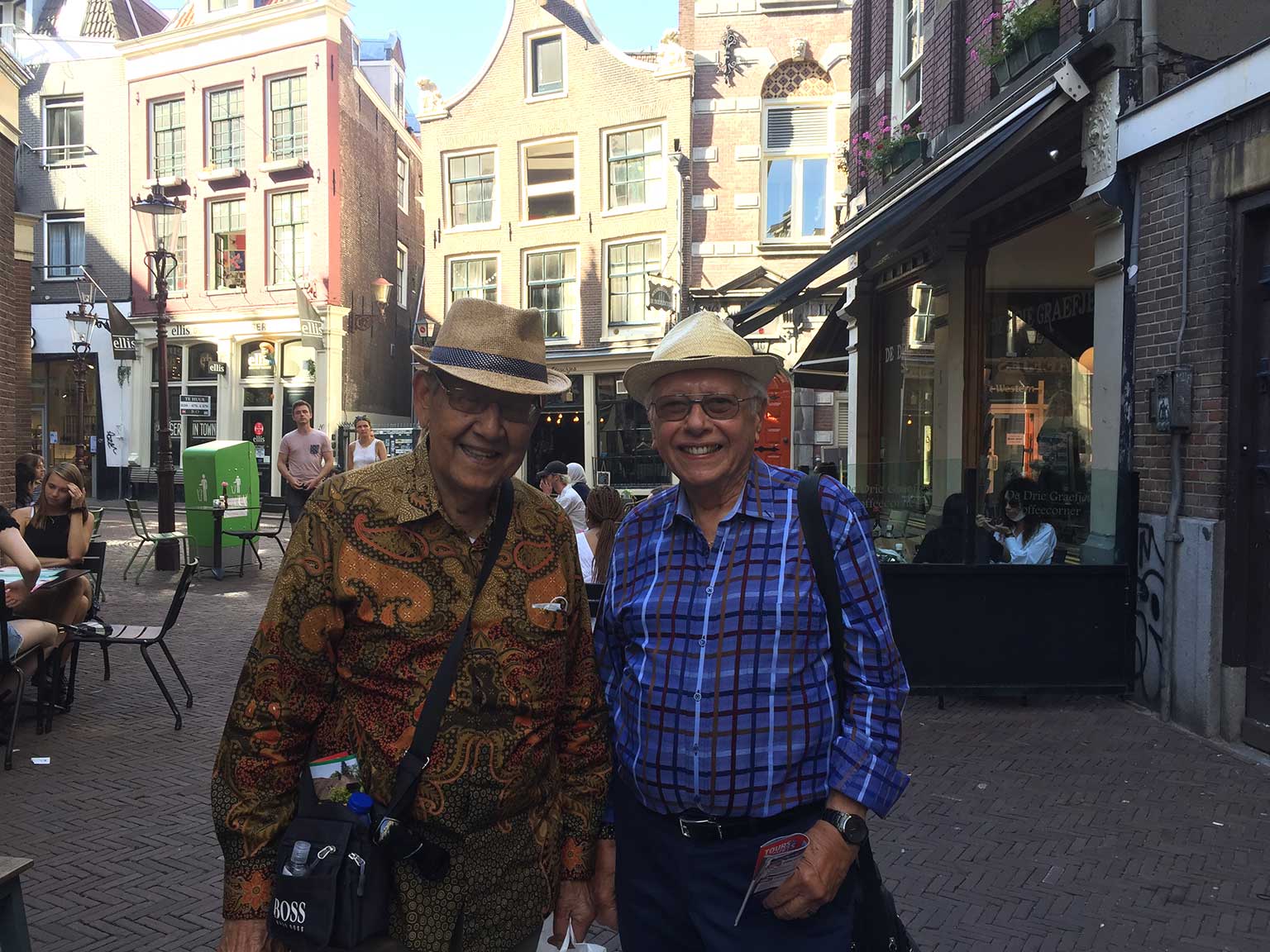 Two happy tourists in front of De Drie Fleschjes on Gravenstraat, Amsterdam