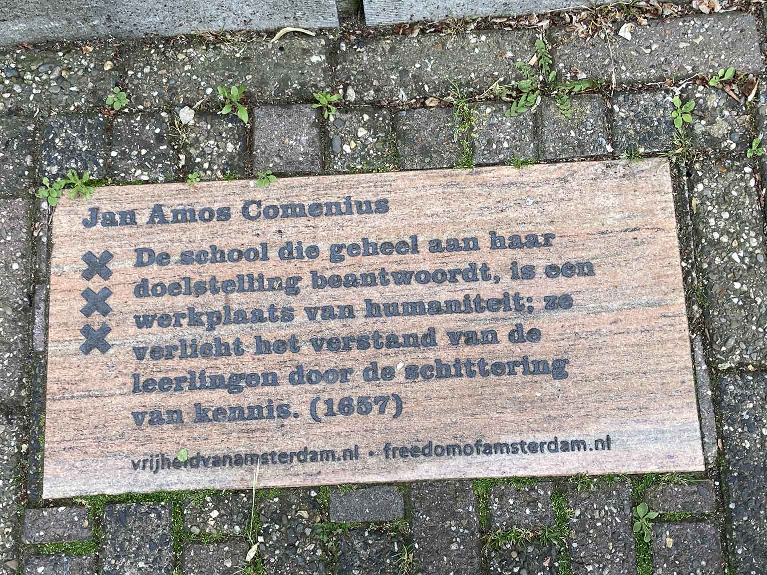 Tile in front of Huis met de Hoofden, Amsterdam, with quote from Comenius