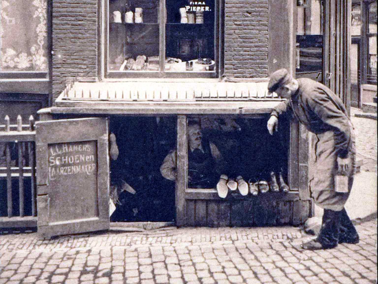 Shoemaker's repair shop in a well house on Nes 87, 1910, Amsterdam