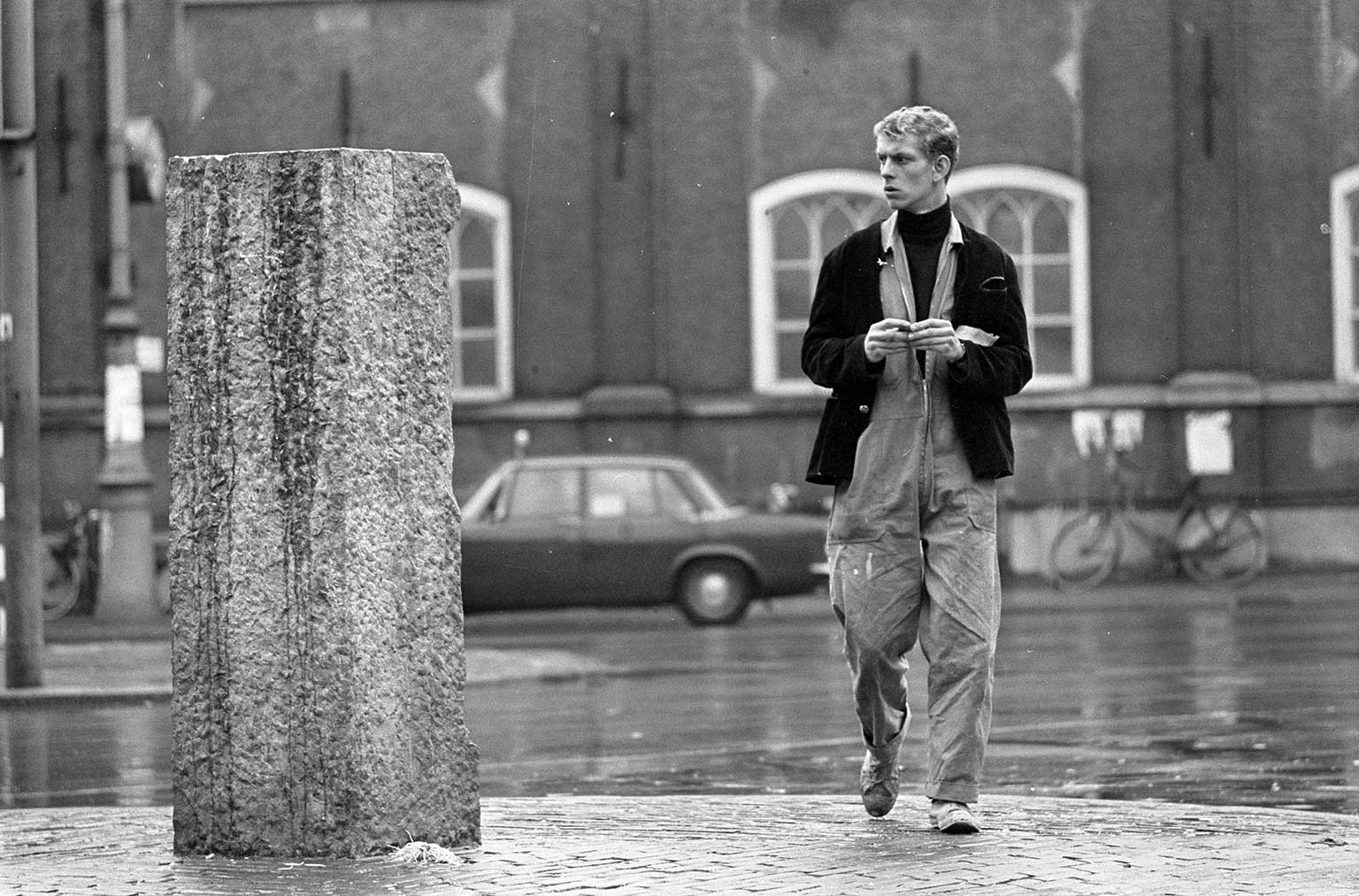 Voorbijganger kijkend naar de lege sokkel van het Lieverdje, Amsterdam, in 1966