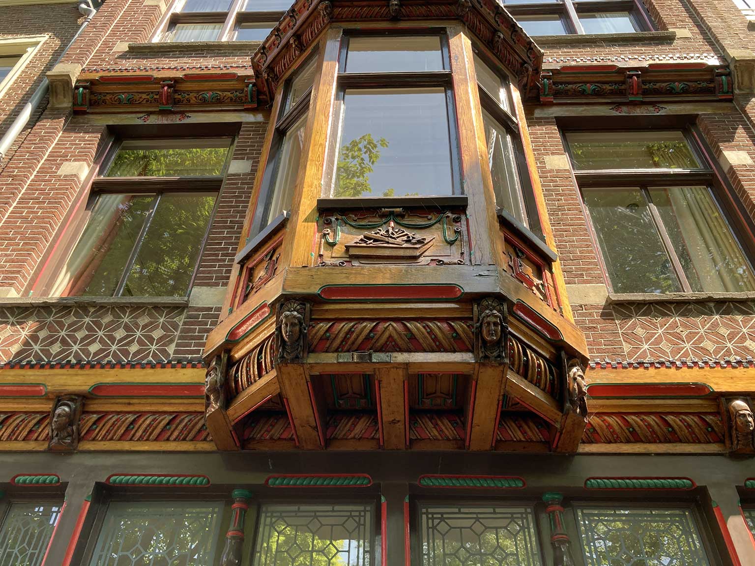 Detail van houtwerk, metselwerk en glas-in-lood ramen op Reguliersgracht 57-59, Amsterdam