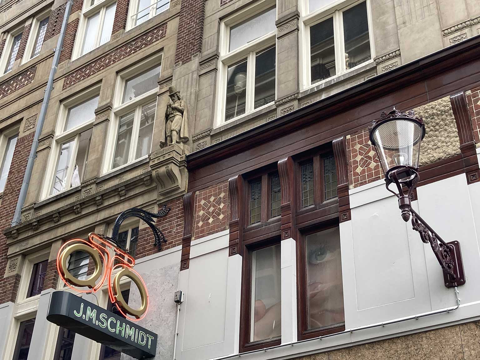 Beeld van Zacharias Jansen op de Wijde Kapelsteeg, Amsterdam, zijkant van het gebouw op Rokin 72