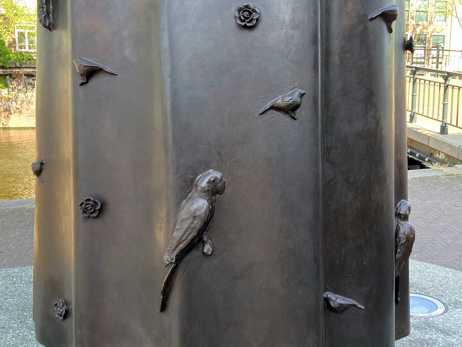 Detail of Spinoza statue, Zwanenburgwal, Amsterdam, with sparrows and roseringed paraqueets