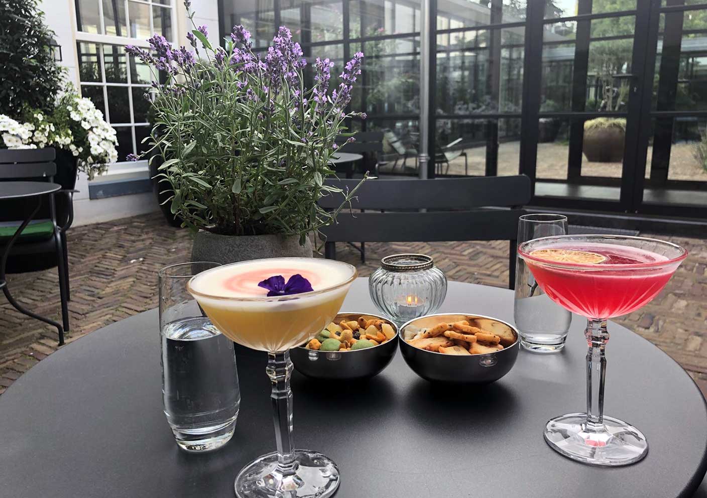 Table with cocktails, and snacks, garden of Pulitzer Hotel, Amsterdam